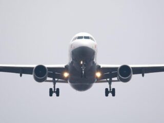 Free A commercial airliner captured head-on, preparing to land against a cloudy sky. Stock Photo