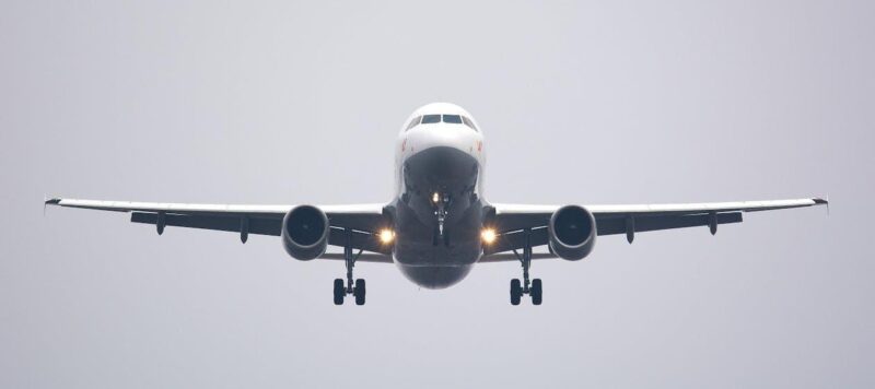 Free A commercial airliner captured head-on, preparing to land against a cloudy sky. Stock Photo